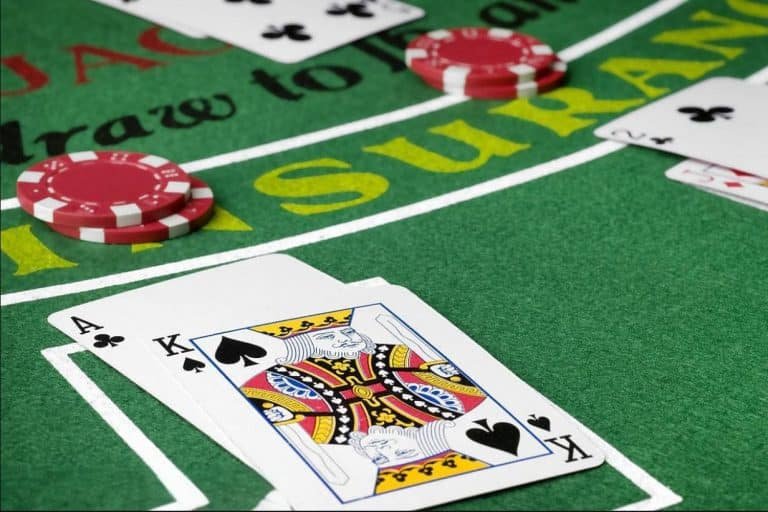 Dealer mengungkapkan kartu dealer dalam putaran Three Card Poker